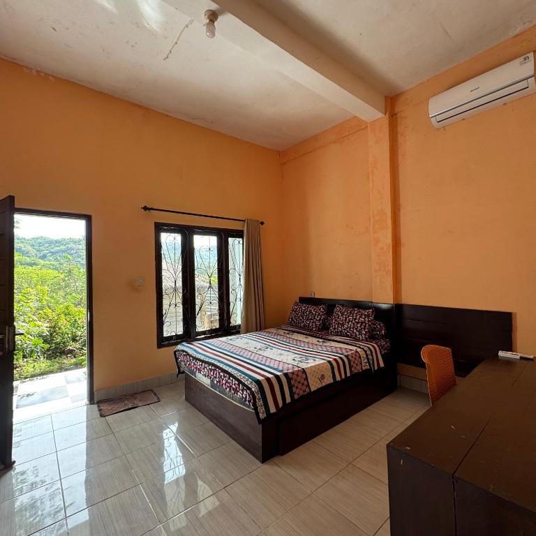 Un dormitorio con una cama y una ventana en Sunrise Bukit Asam Home Stay, en Kuta Lombok