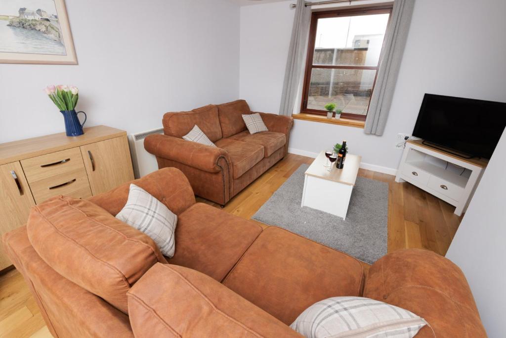 a living room with a couch and a television at Harbour Point, Shetland Islands in Lerwick