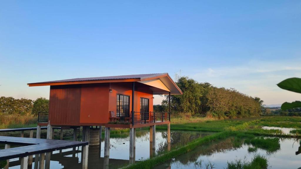 a small house on the water with a table at Ha Me Garden ฮามีการ์เด้น โฮมสเตย์ฝาง in Fang