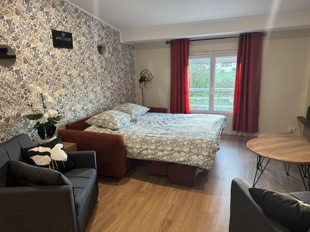 ein Schlafzimmer mit einem Bett, einer Couch und einem Tisch in der Unterkunft L Appart du Suran 