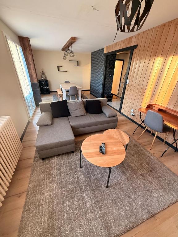 a living room with a couch and a table at Appartement chaleureux familial in Saint-Laurent-en-Grandvaux