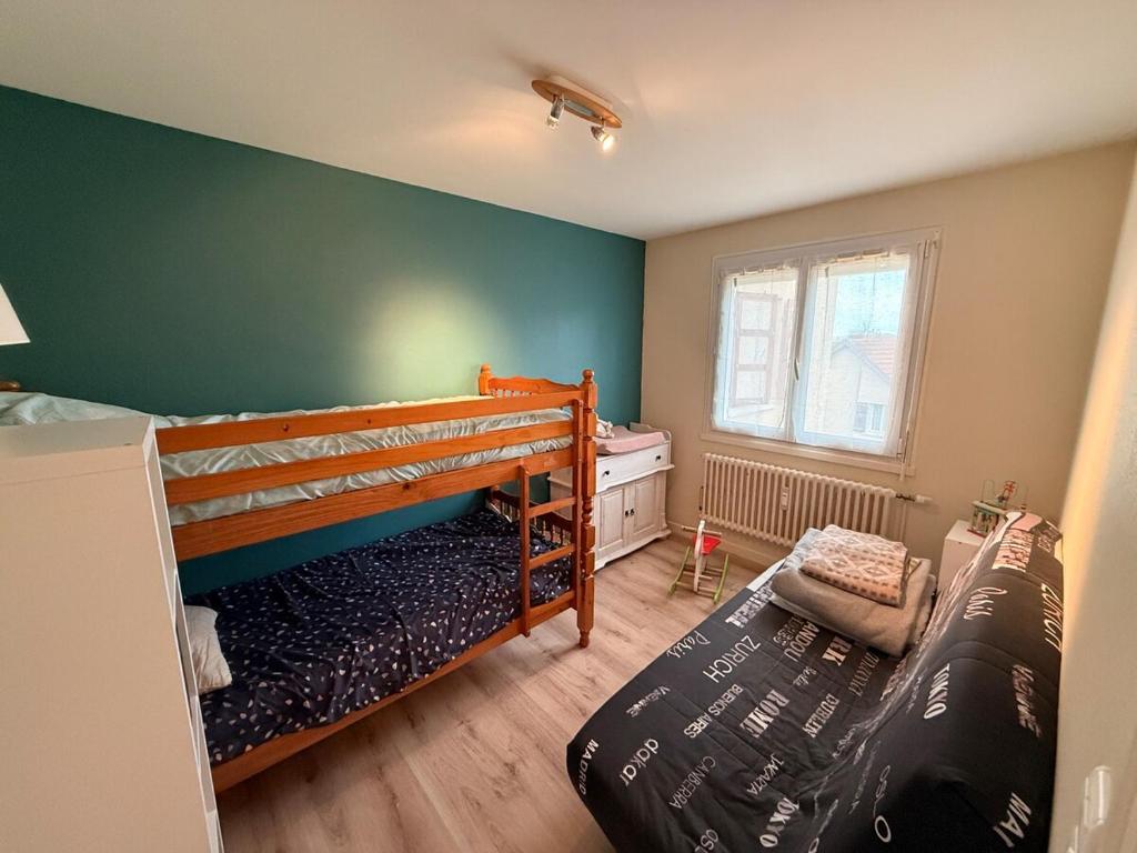 Un dormitorio con dos literas y una ventana. en Appartement chaleureux familial, en Saint-Laurent-en-Grandvaux
