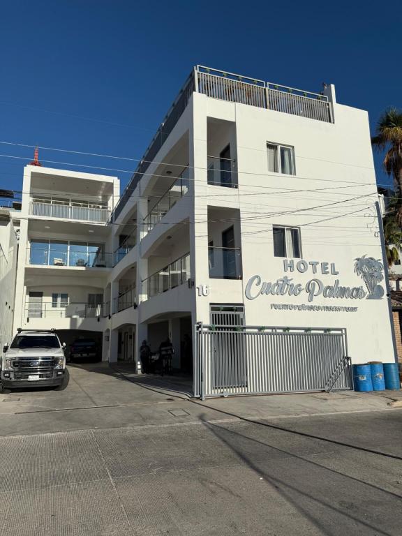 a hotel with a car parked in front of it at Hotel Cuatro Palmas in Puerto Peñasco