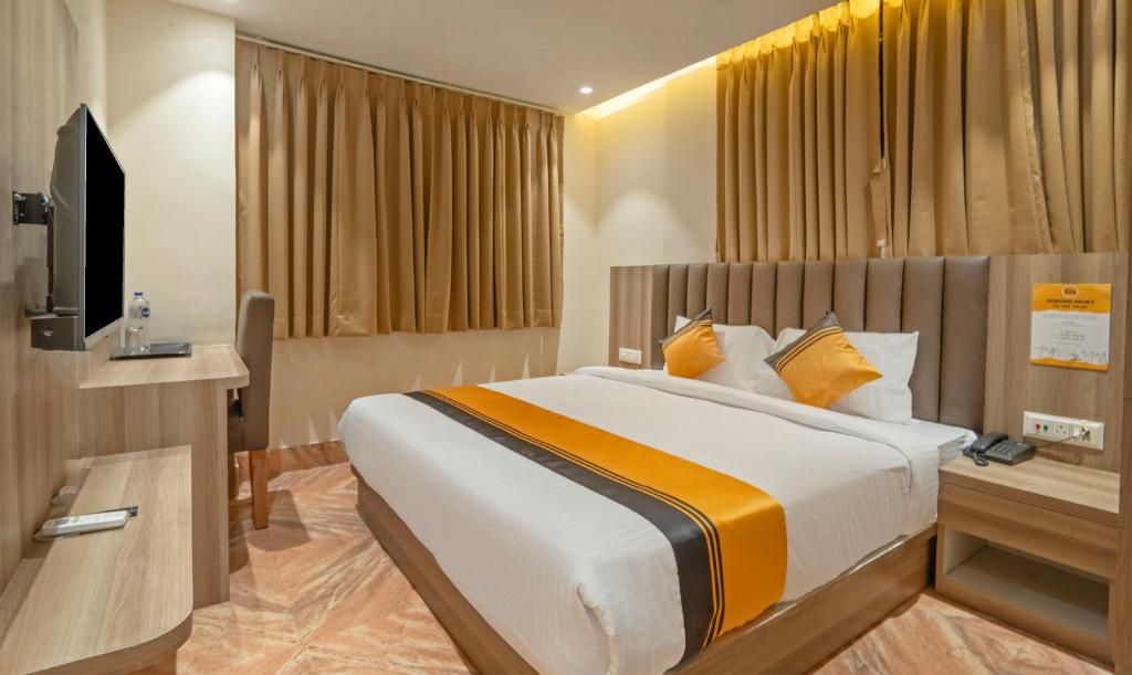 a bedroom with a large bed and a television at Itsy Hotels White Castle in Kolkata