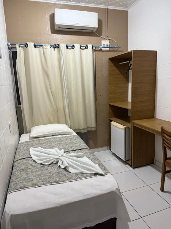 a hospital room with two beds and a desk at Hotel Mapuera in Oriximiná