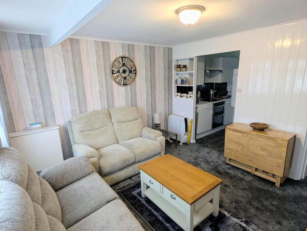 ein Wohnzimmer mit Sofa und Tisch in der Unterkunft Antonia's Place 337 California Sands in Scratby