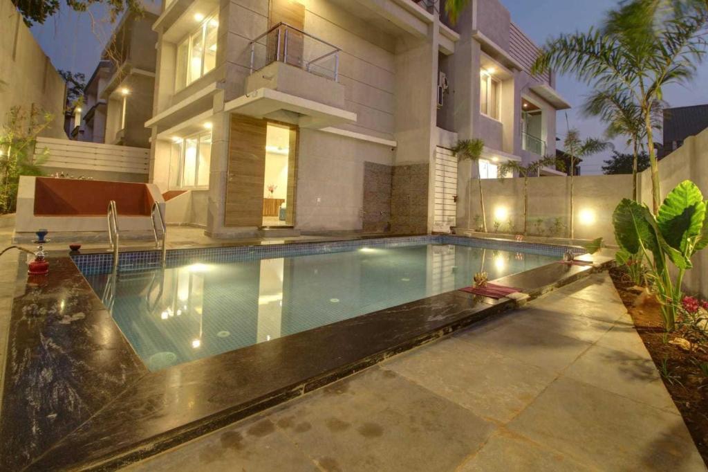 Infinity Luxury Villa - 5BHK | Pool | Baga Beach | DanCenter في آربورا: حمام سباحة أمام منزل