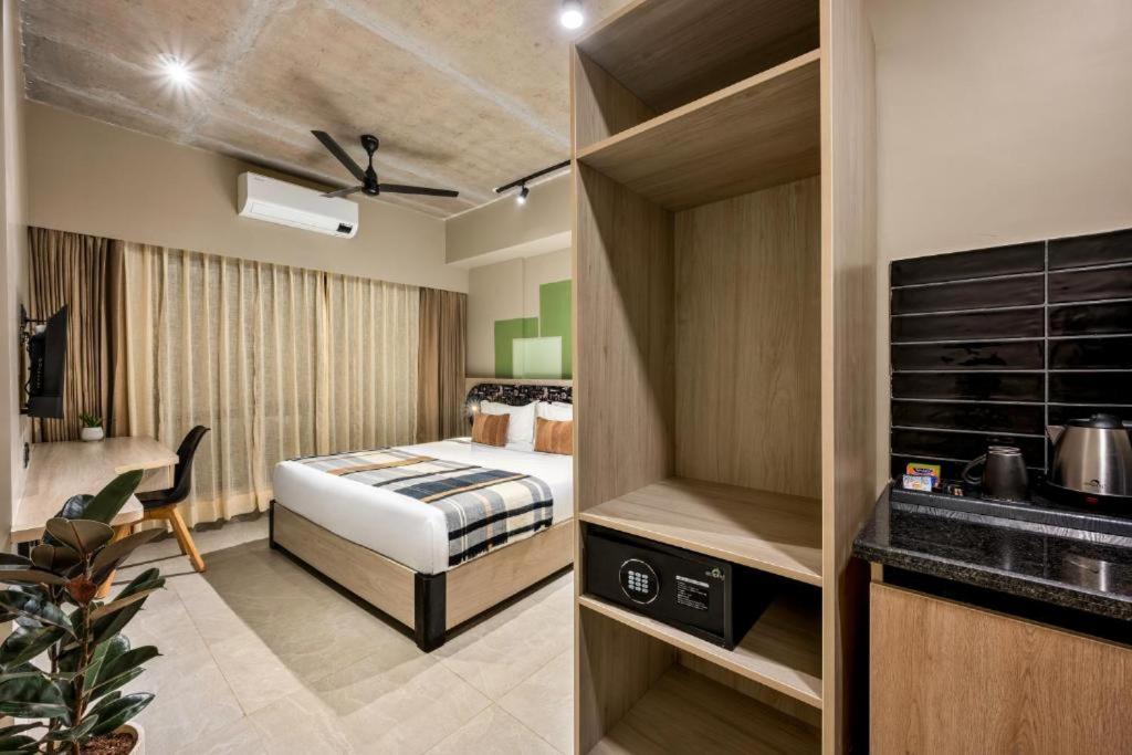 a hotel room with a bed and a desk at Grand Continent Koramangala, Bangalore in Bengaluru