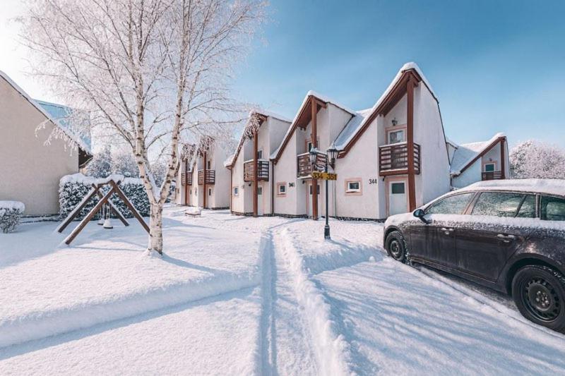 ein Auto, das vor einem Haus im Schnee parkt in der Unterkunft Tatralandia - Apartmán ZOJA in Liptovský Mikuláš