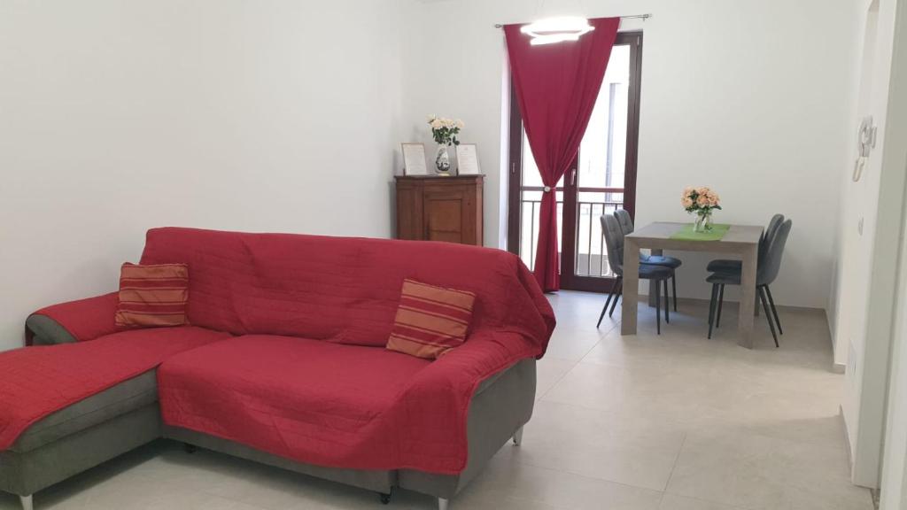 a living room with a red couch and a table at I Giardini Magenta in Magenta