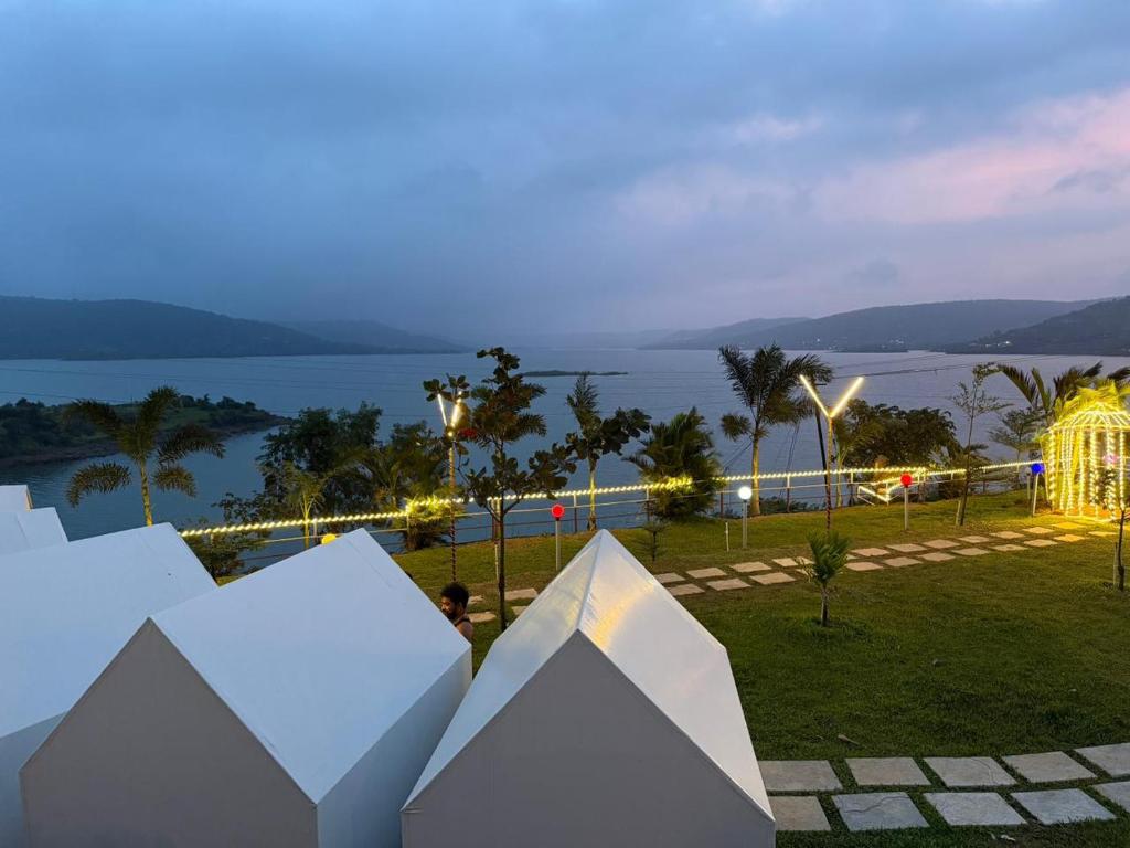 a view of the ocean at night with white buildings at Pawna Lake Camping Bramhnoli in Lonavala