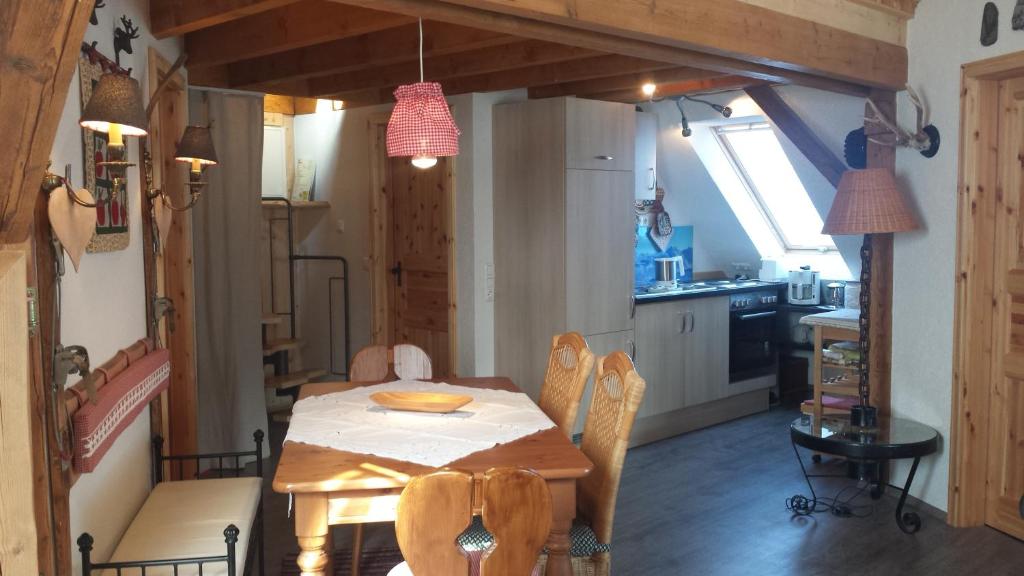 a dining room with a table and a kitchen at Ferienwohnung im kleinen Landhaus in Willingen