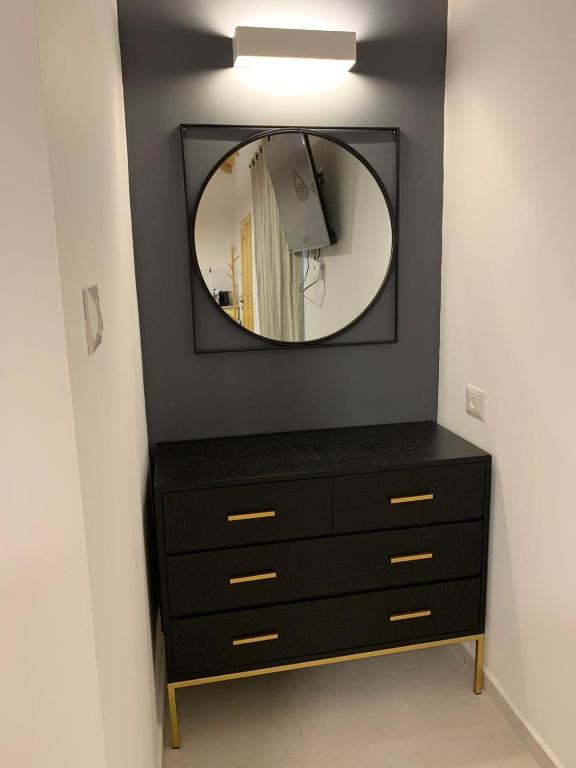 a black dresser with a mirror on a wall at צמרת נופש in Rewaya