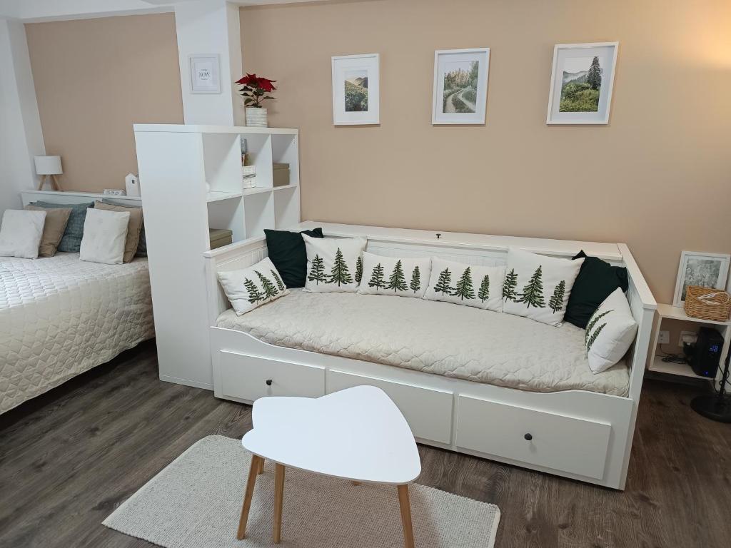 a bedroom with a white bed and a white chair at Apartmán 29 LANOVKA in Jáchymov