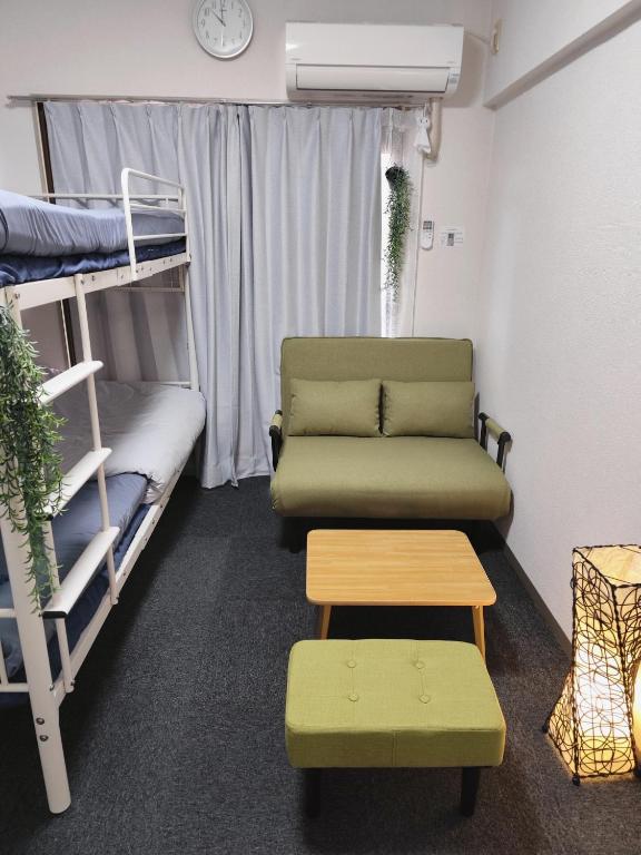 a room with bunk beds and a couch and a table at JKhouse5 in Fukuoka
