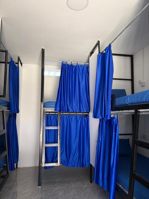 Habitación con 3 literas y cortinas azules. en David's Hostel & Restaurant, en Kaôh Rŭng (3)