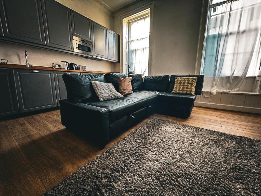 czarna kanapa w salonie z dywanem w obiekcie Coastal 3-Bed Flat near Lowestoft Beach w mieście Lowestoft