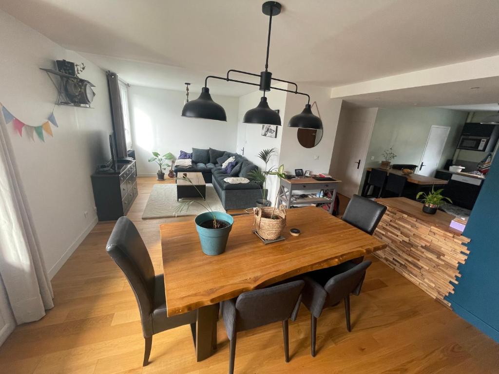 comedor y sala de estar con mesa de madera y sillas en Grand T2 lumineux et cosy - 1min Termes Marlioz, en Aix-les-Bains