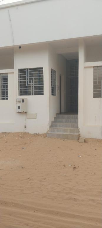 een wit gebouw met trappen en ramen en een gebouw bij Chez Amina in Mbour