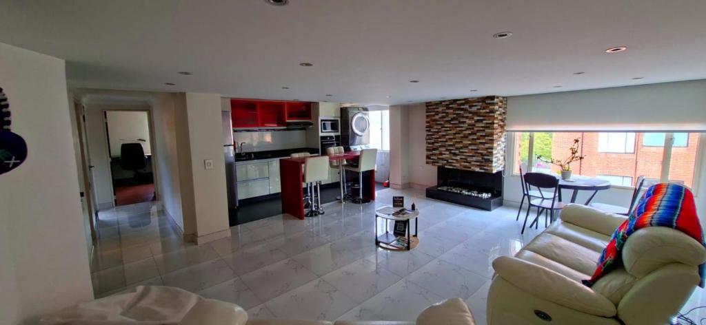 Una sala de estar y una cocina con un sofá y una mesa. en Colina 804, en Bogotá