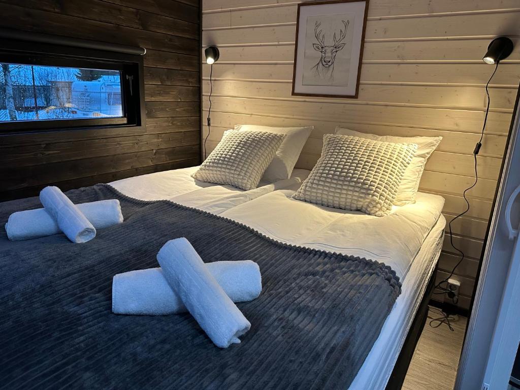a large bed with blue pillows in a room at Santa Elves Cabin in Rovaniemi