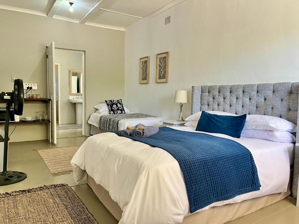 1 dormitorio con 2 camas en azul y blanco en Karoo Velvet, en Beaufort West