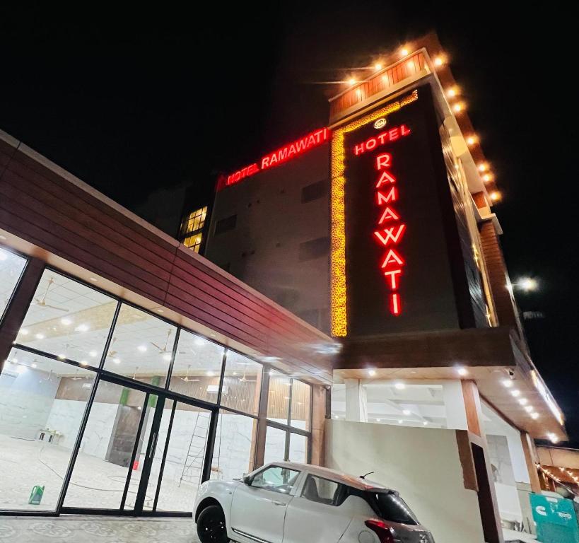 un coche aparcado frente a un edificio con una señal en Hotel Ramawati Classic, A Luxury Hotel & Resort, Haridwar, en Haridwar