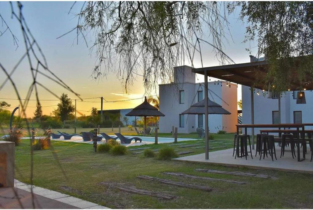 a patio with tables and umbrellas in a yard at Campo Galano in Miramar