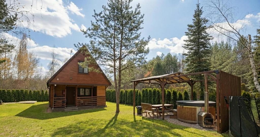 PrażmówCałoroczny, drewniany domek przy lesie的院子里有一间带凉亭的小木屋