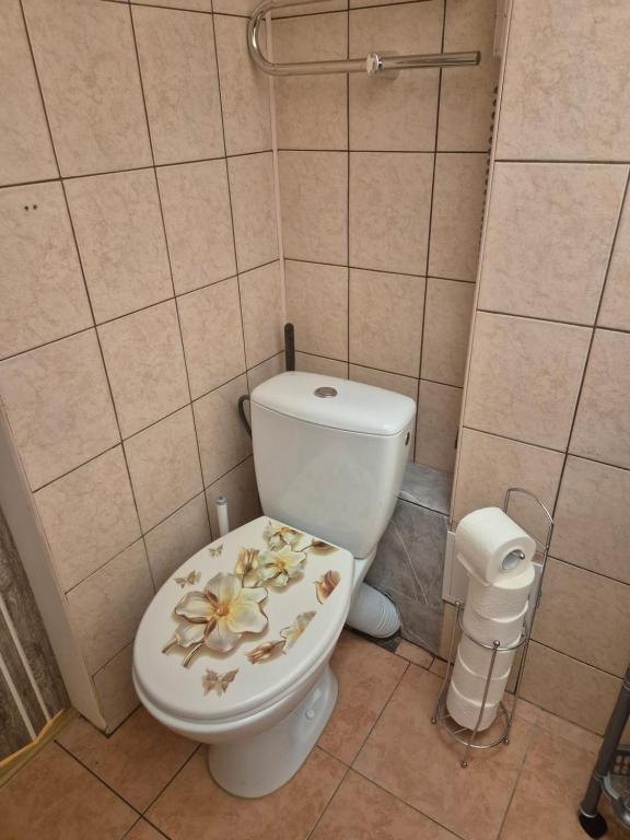 bagno con servizi igienici e fiori sul sedile di Cozy Žemaitės gatvė a Telšiai