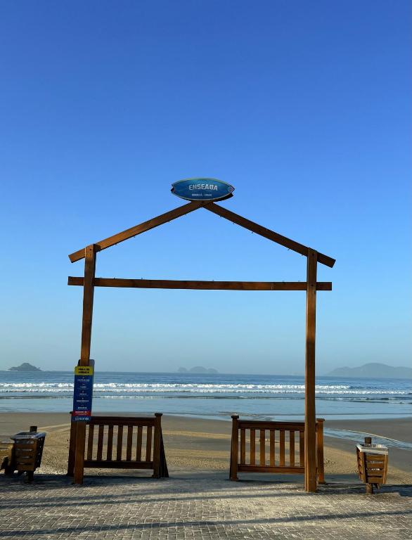 een picknickhut op het strand met banken bij King Midas in Guarujá