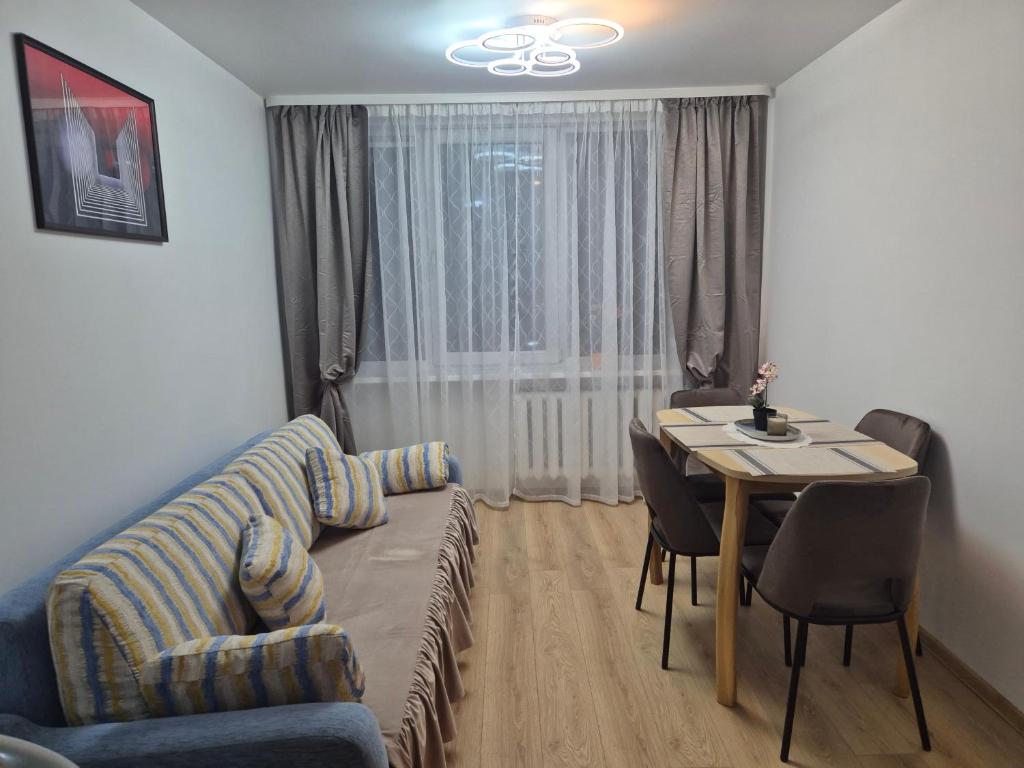 ein Wohnzimmer mit Sofa und Tisch in der Unterkunft Cozy Žemaitės gatvė in Telšiai