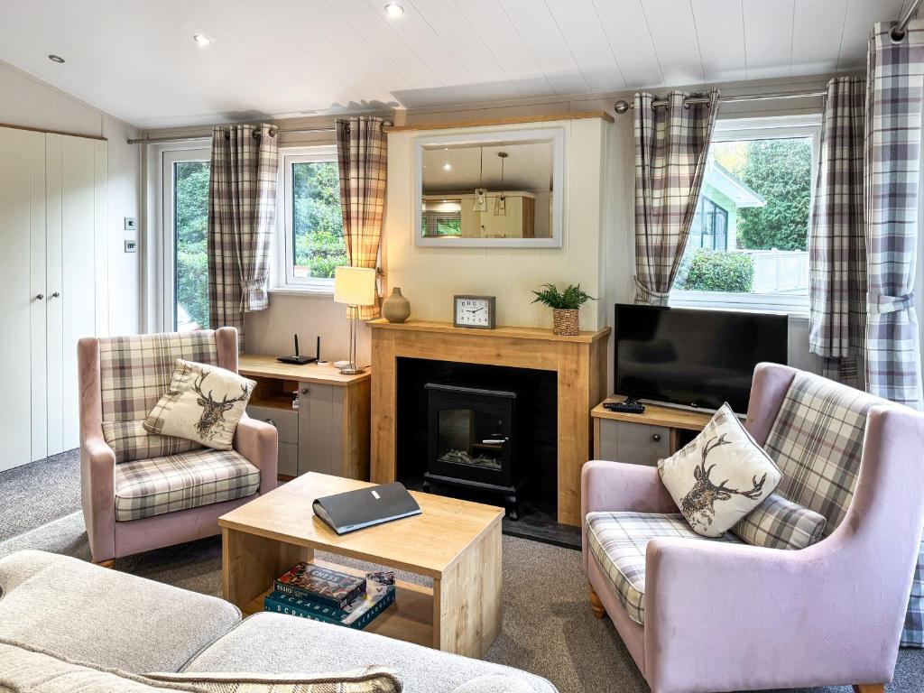 un soggiorno con due sedie e un camino di Portland a Holton Heath