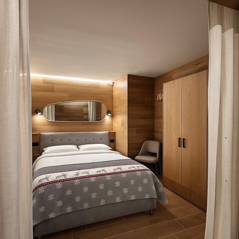 a bedroom with a large bed and a chair at Chalet Campiglio Mountain View - Guardabassi Collection in Madonna di Campiglio