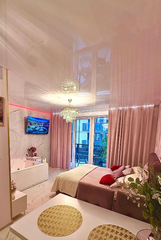 格但斯克Jacuzzi Bliss by the Motława的一间带床、浴缸和水槽的卧室