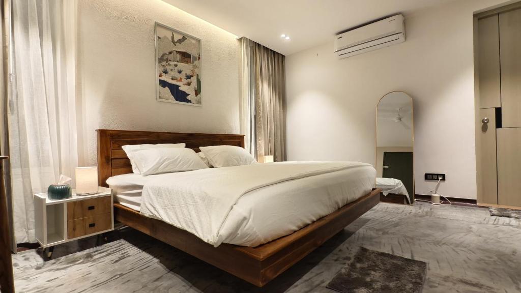 a bedroom with a large bed and a mirror at Reflections by SOL Escapes near Cherai Beach in Pallipuram