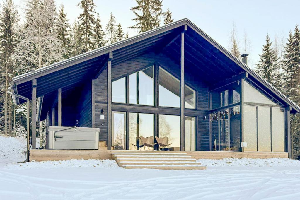 Holiday Villa Rento في Himos: منزل في الثلج في الغابة