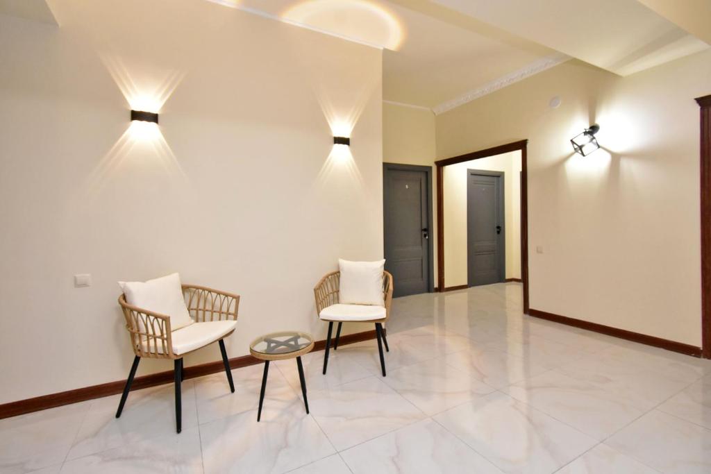 埃里温Perfect的一间设有两把椅子和一张桌子及灯的房间