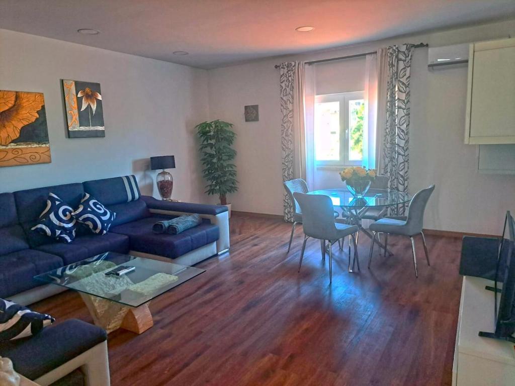 un soggiorno con un divano blu e un tavolo di Moradia T2 com vista para a serra - Alverca a Alverca