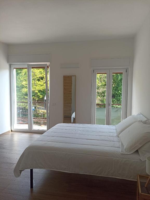 a white bedroom with a large bed and windows at Ciccone's Rooms in Larino