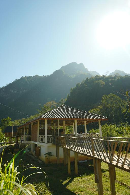 ein Haus mit einem Dach mit Bergen im Hintergrund in der Unterkunft Eco Farm Stay and Hostel in Nongkhiaw