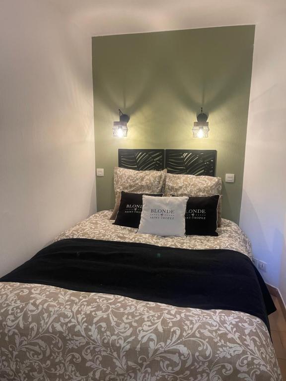 Superbe appartement les Restanques du golfe de Saint tropez في غريمو: غرفة نوم بها سرير ووسادتين عليه