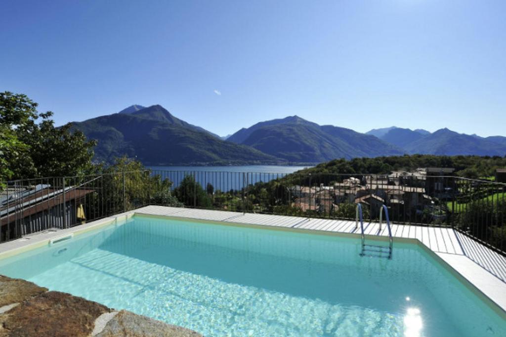 a swimming pool with a view of a lake and mountains at Belmonte Terrazzo in Pianello Del Lario