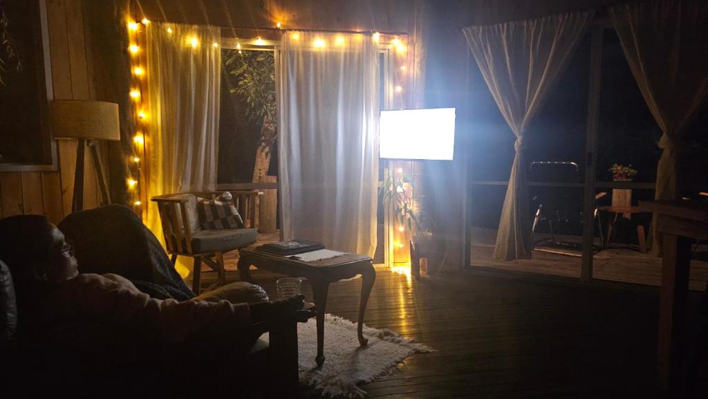 een woonkamer met een bank en een lamp met verlichting bij El octógono in Tigre