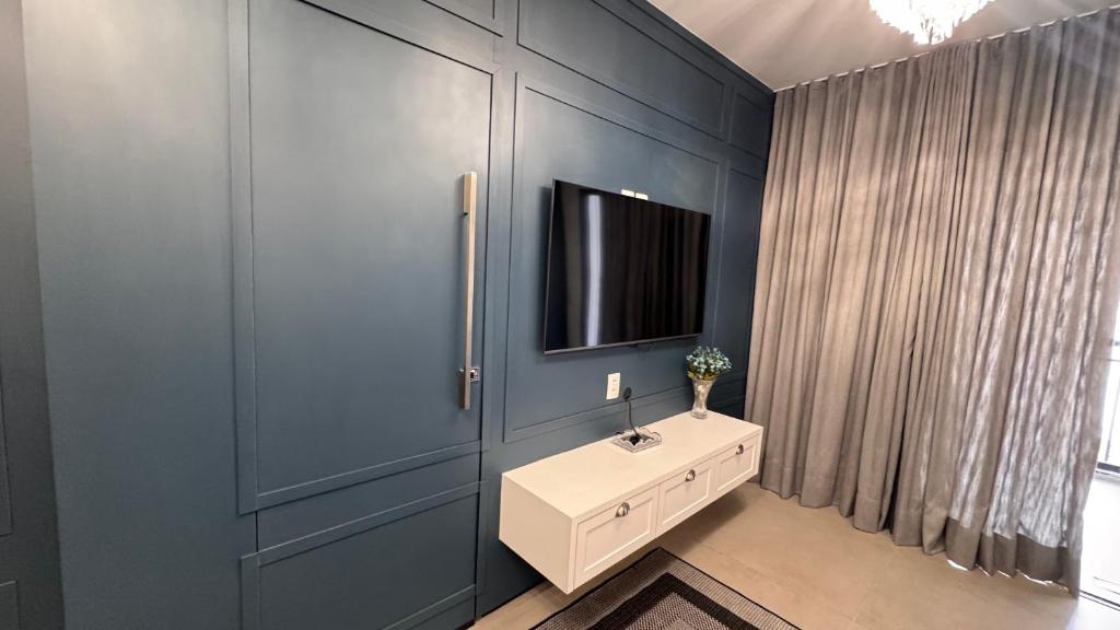 a bathroom with a sink and a tv on the wall at Apartamento Luxuoso 62 - São João in Sao Paulo