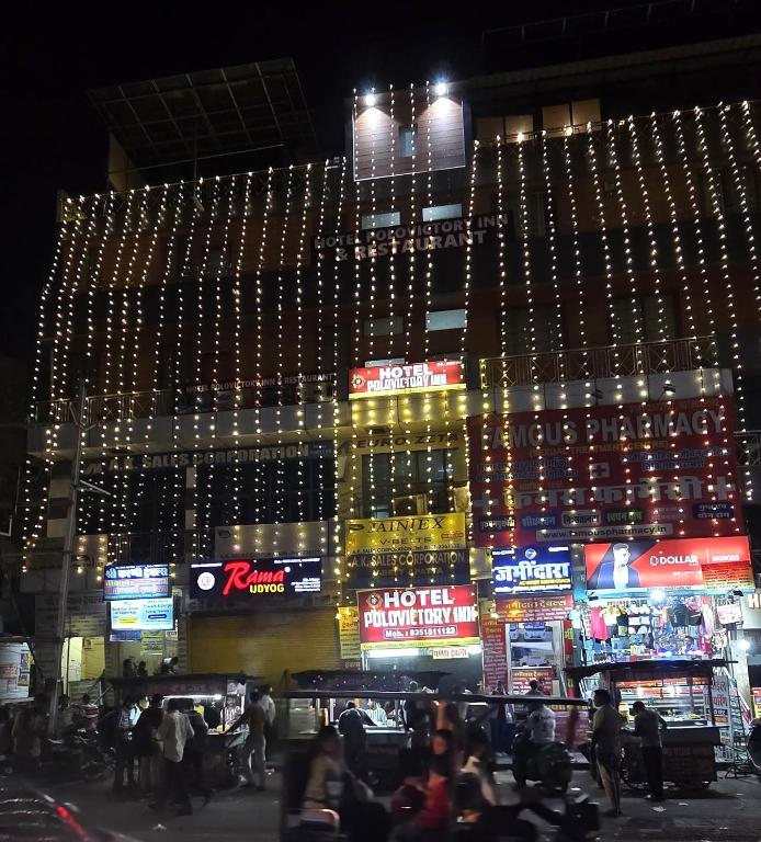 a large building with lights on it at night at Hotel Polovictory Inn in Jāmb