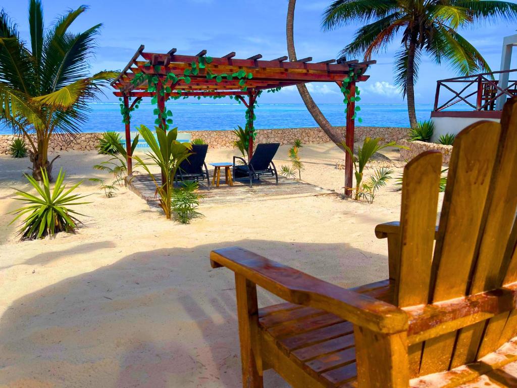 eine Holzbank am Strand in der Nähe des Ozeans in der Unterkunft The Zanzibar Beach House-West in Paje