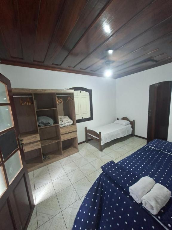 Casa de Hospedagem Flores Paraty 2 في باراتي: غرفة نوم بسرير ازرق ومرآة