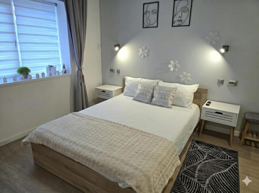 una camera da letto con un letto con lenzuola bianche e una finestra di Casa Pavel a Porumbacu de Sus