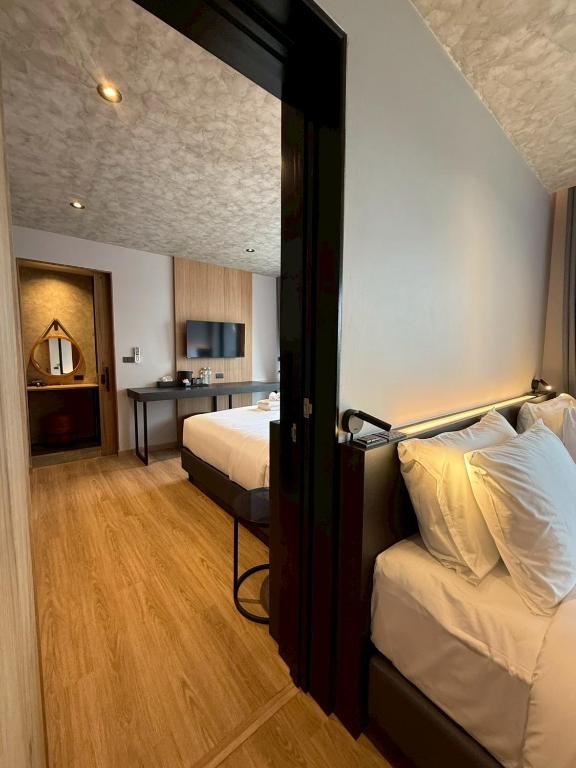 a hotel room with a bedroom with two beds at Lush inn Phuket in Ban Suan